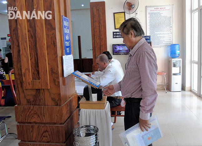 A local resident reading online information about public services at the headquarters of the Hoa Hiep Nam Ward People’s Committee