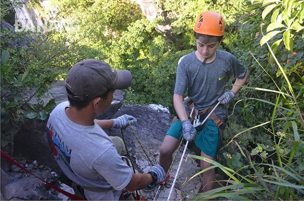  A foreigner (right) preparing for a climb at the Marble Mountain Tourist Area