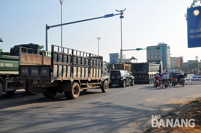 Nhiều xe tải, xe ben, cùng xe máy xếp hàng chờ qua nút giao thông Cách mạng Tháng Tám - Nguyễn Hữu Thọ - đường dẫn cầu Nguyễn Tri Phương.