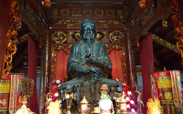   This bronze statue of Huyen Thien Tran Vu was cast in 1677 during the reign of Emperor Le Hy Tong.  The statue features his square face, long beard, and hair untied.  He is sitting, with a sword in his right hand, on a stone platform which is encircled by a snake and supported by a tortoise.  This is a special work of art which demonstrates the skills of bronze casting and statue sculpturing in Ha Noi over 3 centuries ago.