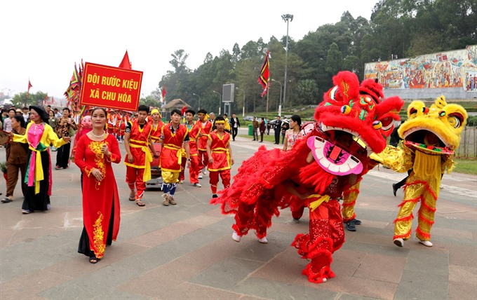 Dragon steps: The palanquin team from Chu Hóa Commune at the foot of the Nghĩa Lĩnh Mountain is accompanied by a dragon dance team. — VNS Photo Nguyễn Trung Kiên Read more at http://vietnamnews.vn/life-style/374094/hung-kings-day-honouring-founding-fathers.html#wg5tLQ7CWsS5itqP.99