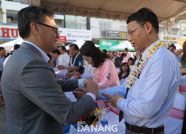 Đại sứ Thongsavanh Phomvihane thực hiện nghi thức buộc chỉ cổ tay cầu phúc cho Phó Chủ tịch UBND thành phố Hồ Kỳ Minh