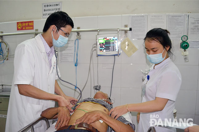 Bác sĩ Dương Ngọc Thành (trái) cấp cứu một bệnh nhân mắc bệnh lao phổi giai đoạn 2.