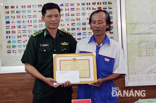 Mr Van (right) receiving his award from a border guard representative