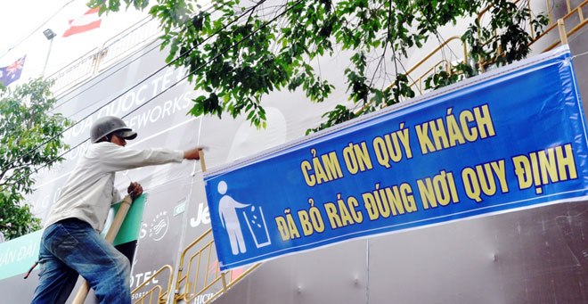 Công nhân Công ty CP Môi trường Đô thị Đà Nẵng treo băng rôn “Cảm ơn quý vị đã bỏ rác đúng nơi quy định”.