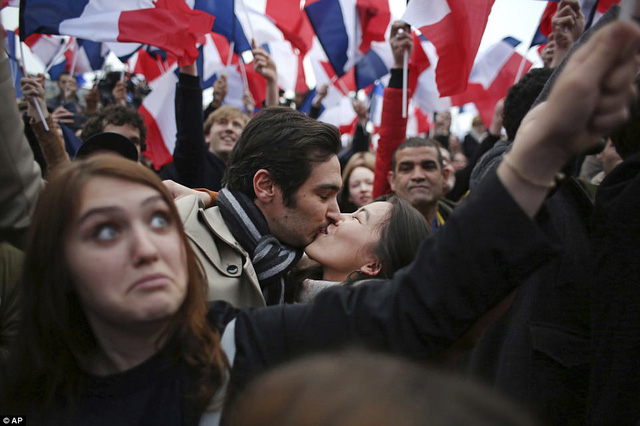 Một cặp đôi hôn nhau khi ăn mừng chiến thắng của ông Macron. (Ảnh: AP)