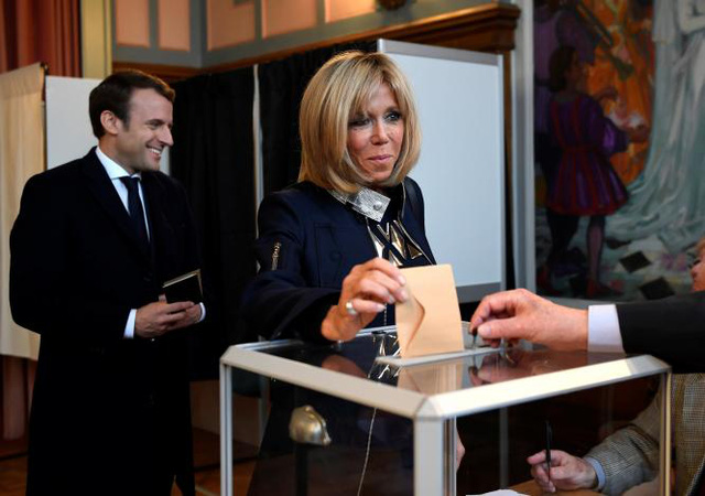 Reuters cho biết, sau khi ông Macron trở thành tổng thống, bà Brigitte Trogneux có thể sẽ đóng vai trò là cố vấn quan trọng của chồng. Trong ảnh: Vợ chồng ông Macron tại một điểm bỏ phiếu ngày 7/5. (Ảnh: Reuters)