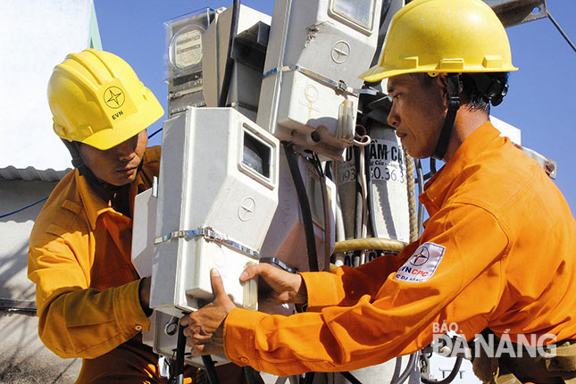 Công nhân Điện lực Đà Nẵng lắp đặt đồng hồ trên trụ điện.