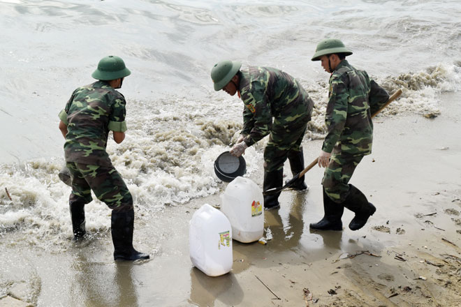 Lực lượng quân đội tham gia thu gom dầu trôi dạt vào bờ sông Hàn.