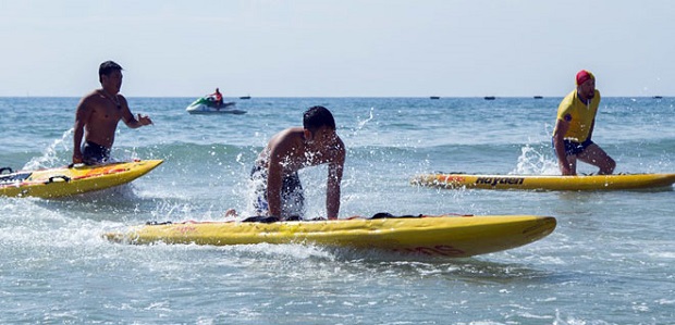 Contestants in the swimming with surfboards category …