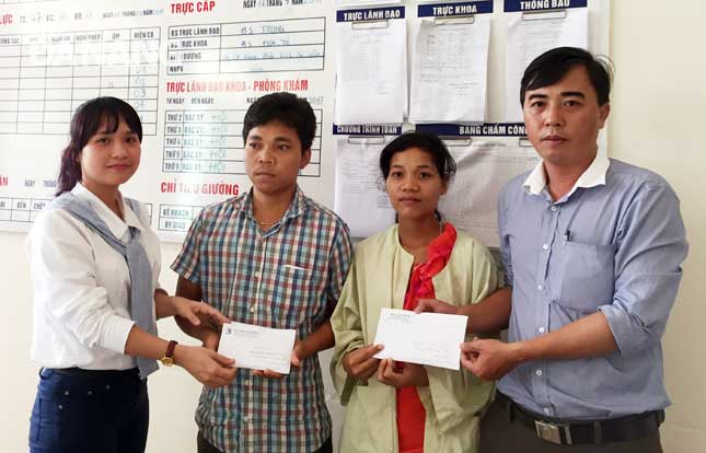 A representative from the newspaper’s Reader Department (right) and the one from the University (left) handing the donation to Quan’s parents