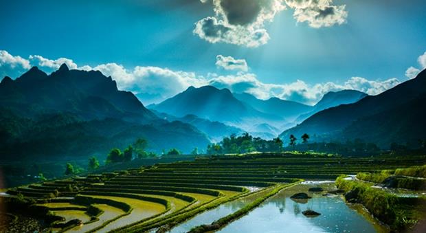 Farmers in the north-western region often dry their fields during May and June. After that, they pour water into the soil. The water flows from ravines through bamboo tubes to fill the fields, creating multicoloured paintings: the yellow of the alluvium, the greenish colour of young rice sprouts freshly sown and the reflected colour of the blue sky.