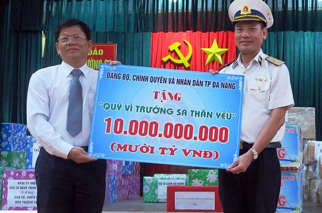 Deputy Secretary Tri (left) presenting 10 billion VND to a representative officer 