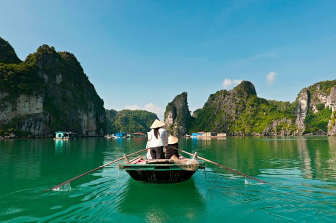 A woman sails a boat in Ha Long Bay. Photo by VnExpress