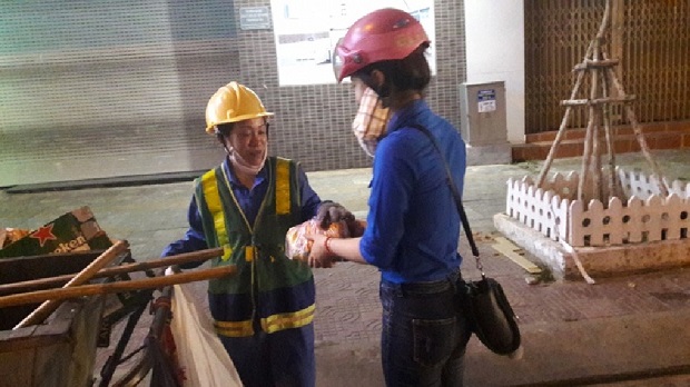 A Youth Union member giving food to a local sanitation worker 