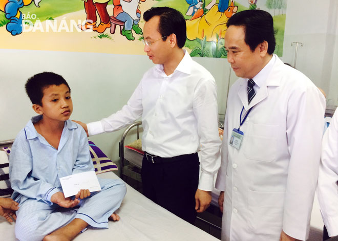 Secretary Anh (centre) speaking to a child patient at the city’s Cancer Hospital