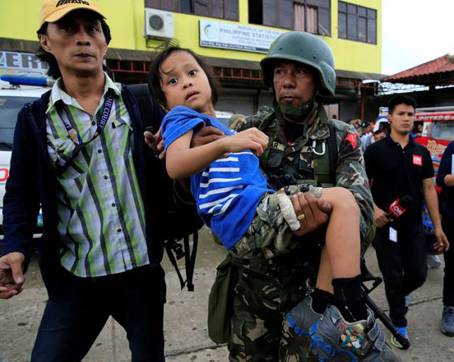 Quân đội Philippines hỗ trợ người dân đi sơ tán khỏi Marawi.      Ảnh: International Business Times