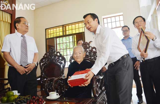 Secretary Anh (right) presenting a gift to Mrs Khoi …