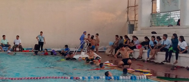 Children learning how to swim at a local high school