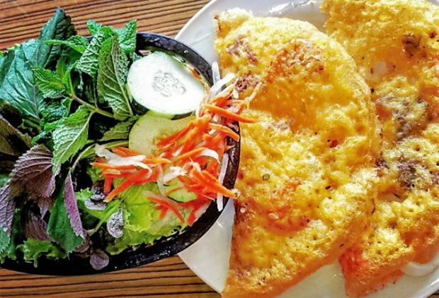 Banh xeo, crispy Vietnamese pancakes that go with fish sauce and fresh herbs.