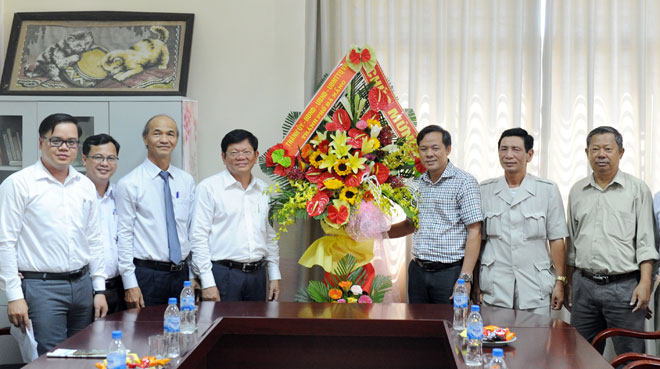 Deputy Secretary Tri (4th left) congratulating the city’s branch of the Nhan Dan Newspaper and…