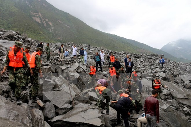 Nhân viên cứu hộ nỗ lực tìm kiếm người mất tích trong vụ lở đất. (Nguồn: AFP/TTXVN)