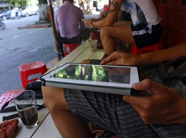 A man surfs the internet on his tablet at a café in Ha Noi. Photo by AFP