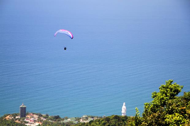 A pilot flies over a pagoda on Son Tra peninsula.