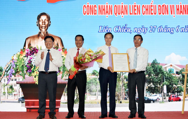 Phó Bí thư Thường trực Thành ủy Đà Nẵng Võ Công Trí (bìa trái) tặng hoa chúc mừng quận Liên Chiểu trở thành đơn vị hành chính loại 1.