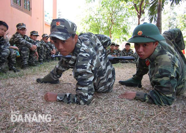 “Chiến sĩ nhí” luyện tập các tư thế vận động trên chiến trường với sự hướng dẫn của tiểu đội trưởng (phải).