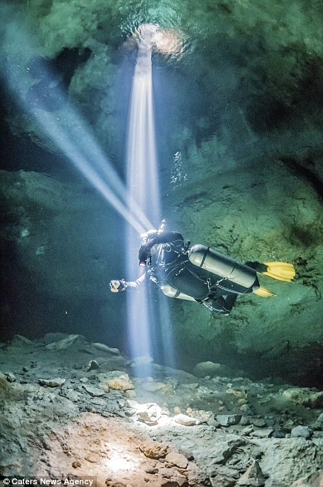 Một thợ lặn rọi đèn để khám phá sâu trong lòng hang