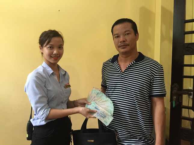 A Ba Na Hills staff member (left) returning the money to Mr Chau