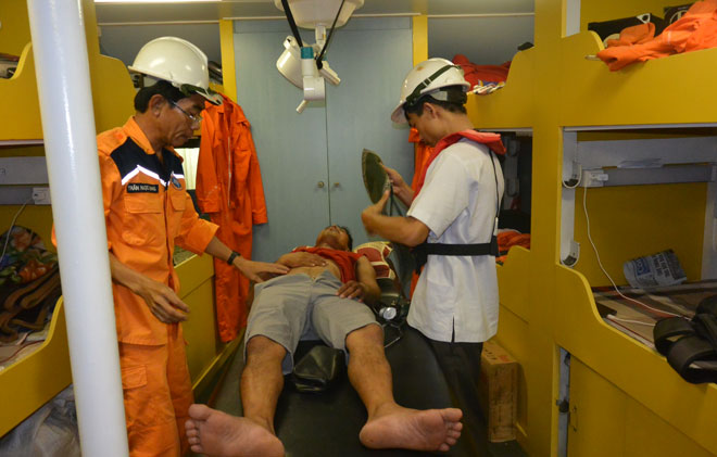 Bác sỹ sơ cứu cho ngư dân trước khi đưa về bờ cứu chữa