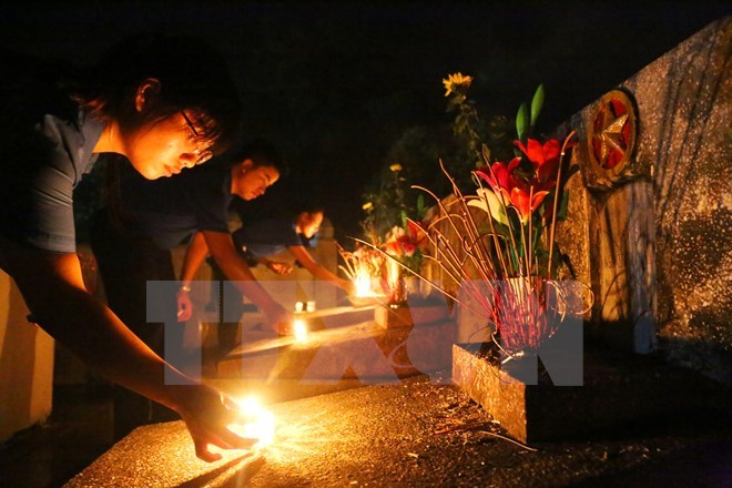 Candle lighting and incense offering to war martyrs. President Tran Dai Quang has signed decision to present gifts to Vietnamese heroic mothers, war martyrs’ relatives and invalids. (Photo: VNA)