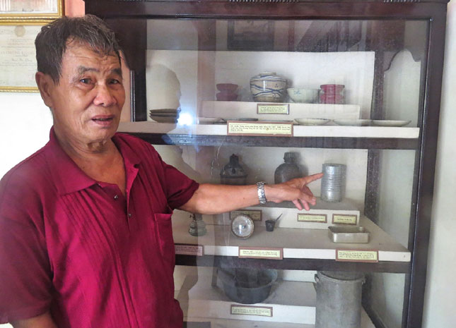 Ông Phạm Phú Lý giới thiệu chén đĩa và hộp thiếc mà Mẹ Nhu từng dùng để đưa cơm xuống hầm cho các chiến sĩ.