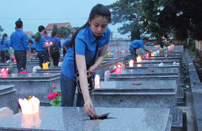 Các đoàn viên thanh niên thắp nến cho hơn 700 phần mộ anh hùng, liệt sĩ. Ảnh: TS