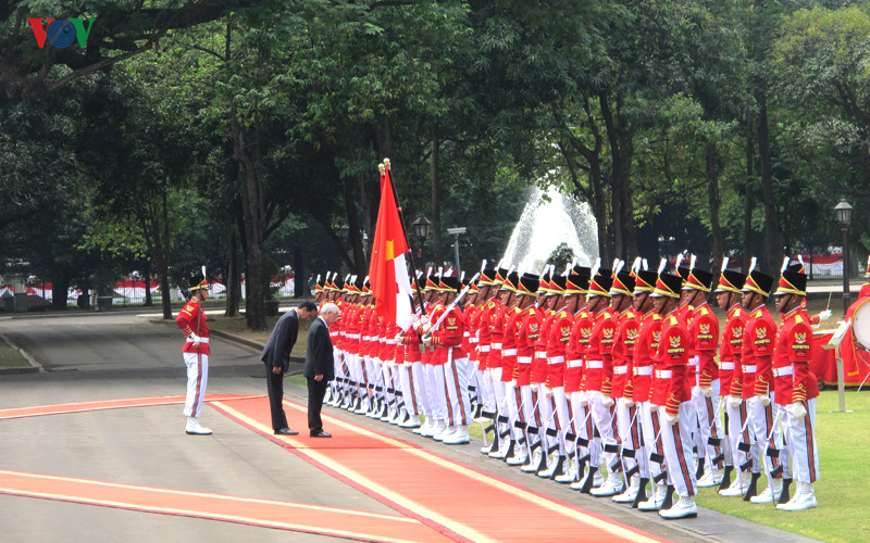 Tổng Bí thư Nguyễn Phú Trọng và Tổng thống Joko Widodo cùng cúi chào Quốc kỳ hai nước.