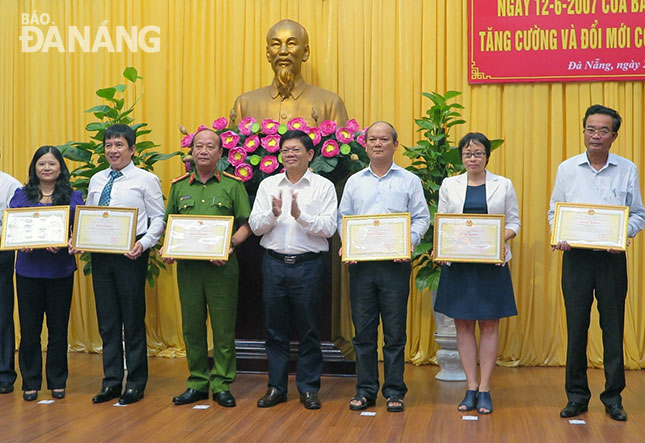 Deputy Secretary Tri (centre) presenting Certificates of Merit to the outstanding groups