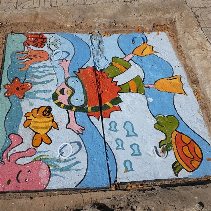 Art space: A manhole cover painted with a lively ocean scene. Read more at http://vietnamnews.vn/life-style/392853/students-create-river-side-art-space.html#GehTbockY83BXohT.99