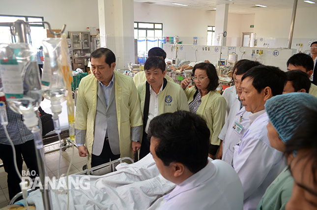 Chủ tịch UBND thành phố Huỳnh Đức Thơ thăm nạn nhân tai nạn lao động tại Bệnh viện Đà Nẵng.   Ảnh: PHAN CHUNG