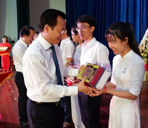 Secretary Anh presenting gifts to local outstanding pupils