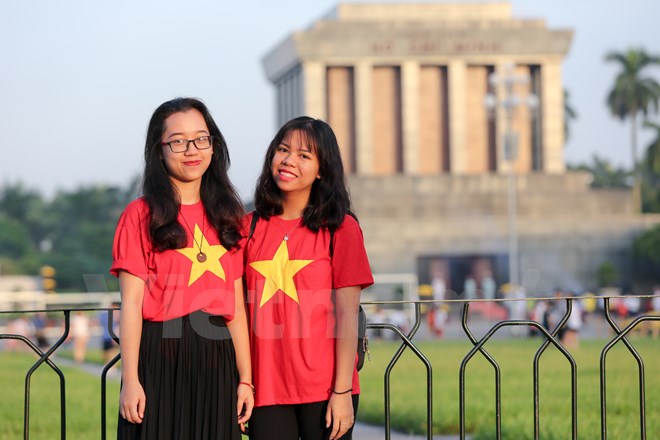 Một vài bạn đã cùng nhau mặc áo cờ đỏ sao vàng trong ngày Quốc khánh. (Ảnh: Minh Sơn/Vietnam+)