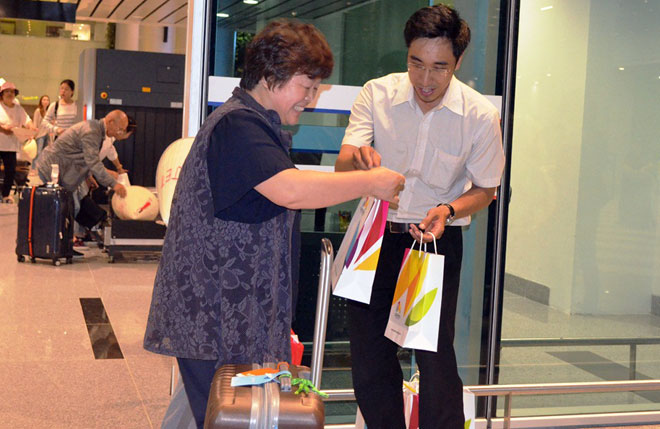 Đại diện Trung tâm xúc tiến Du lịch Đà Nẵng tặng quà cho những vị khách trên chuyến bay đầu tiên