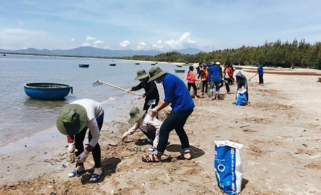 Students from the University of Economics collecting garbage on a beach in Tam Hai Island Commune