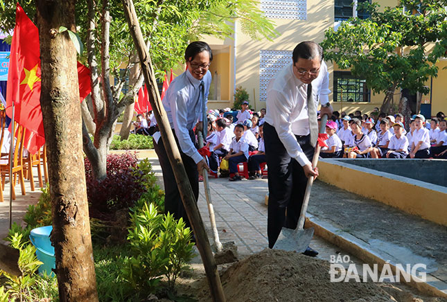 Chủ tịch UBND thành phố Huỳnh Đức Thơ (phải) trồng cây lưu niệm tại Trường tiểu học Tô Hiến Thành.  							                 Ảnh: PHAN CHUNG