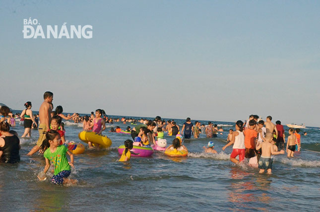 A local beach is crowded with swimmers