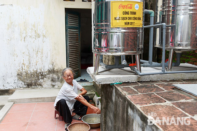  A local senior woman feels happy with clean water 