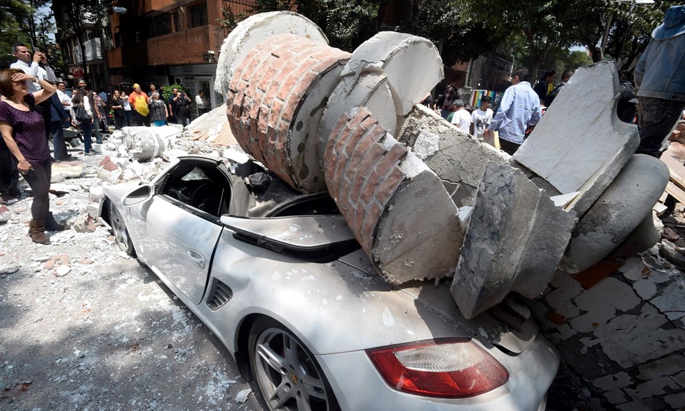 Gạch đá từ một tòa nhà đổ sập rơi đè nát một chiếc xe hơi ở thủ đô Mexico City. (Nguồn: AFP)