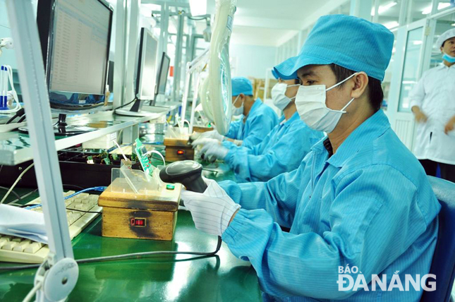 Công nhân đang sản xuất công-tơ điện tử tại Xưởng sản xuất thiết bị điện tử - Trung tâm Sản xuất thiết bị đo điện tử Điện lực miền Trung.