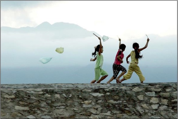 Children running on Lang Co Beach’s embankment